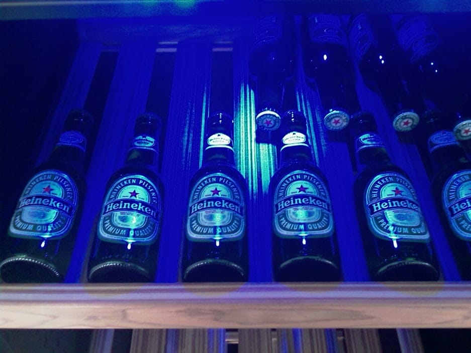 Rangées de caves climatiques à bière (450 litres, hauteur 180 cm, zones multiples) éclairées par lumière bleue sur des étagères en bois.