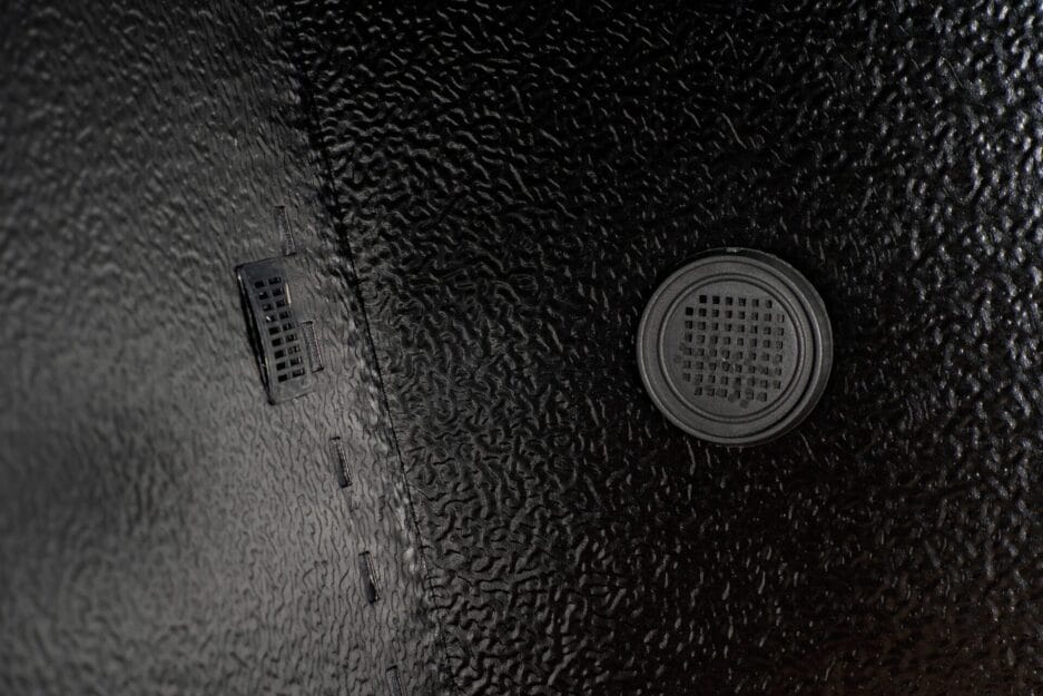 Close-up of a wine cooler (40 bottles, multi-zone, 84cm height) with round speaker grille and rectangular ventilation opening.