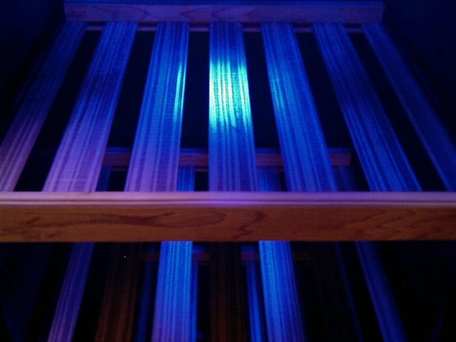 Ein Weinklimaschrank mit blauen Drähten, die unter blauer Beleuchtung beleuchtet werden und einen ruhigen, leuchtenden Effekt erzeugen.