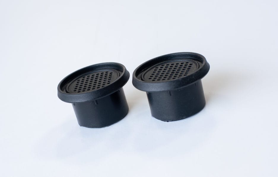 Two Activated carbon filter coffee pad lids on a white background.