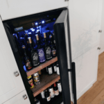 Eine eingebaute Kühlschrankschublade öffnete sich teilweise und gab eine Sammlung verschiedener Lagerregale frei.