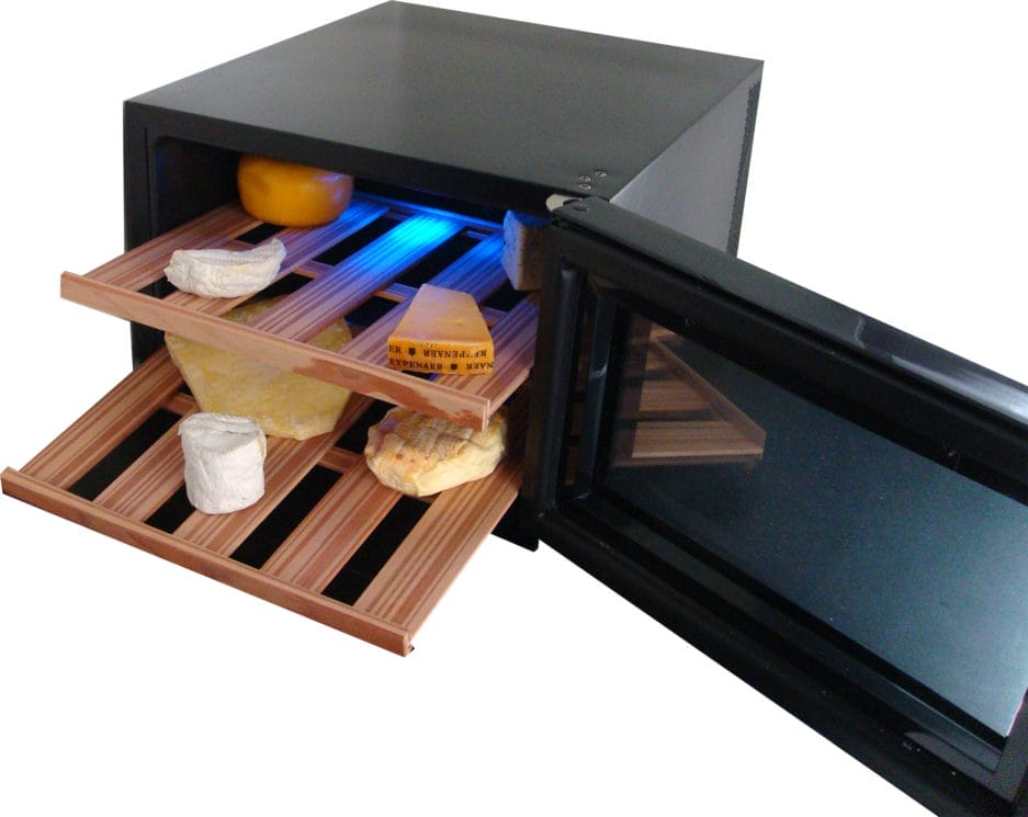 Une armoire climatique à fromages avec une porte ouverte, avec des étagères remplies de divers fromages sous lumière UV.