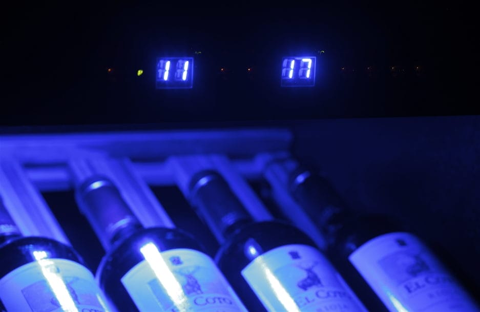 Een wijnkoeler met blauwe verlichting waarop flessen el coto-wijn worden weergegeven, met een digitale temperatuurweergave van 11 graden Celsius.