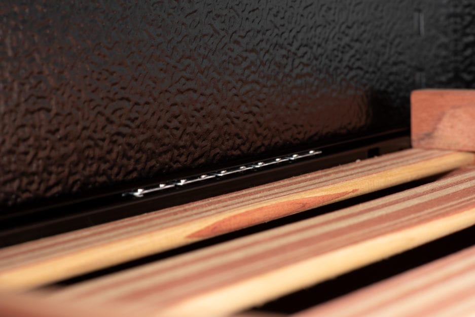 Close-up of unlit matches resting on a striped surface with a blurred black textured background.