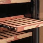 Een close-up van een open, houten sigarenhumidorlade, met de constructie en lege sleuven.