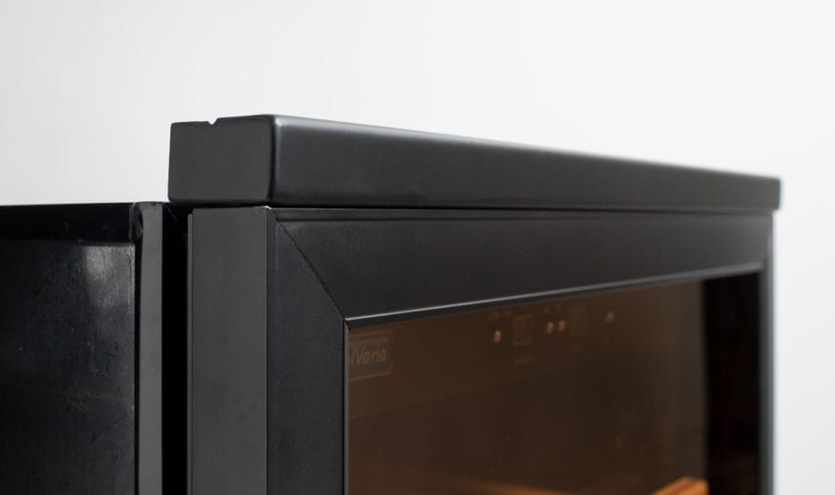 Close-up of a black built-in microwave set with visible branding, focusing on the top corner where it meets another appliance.