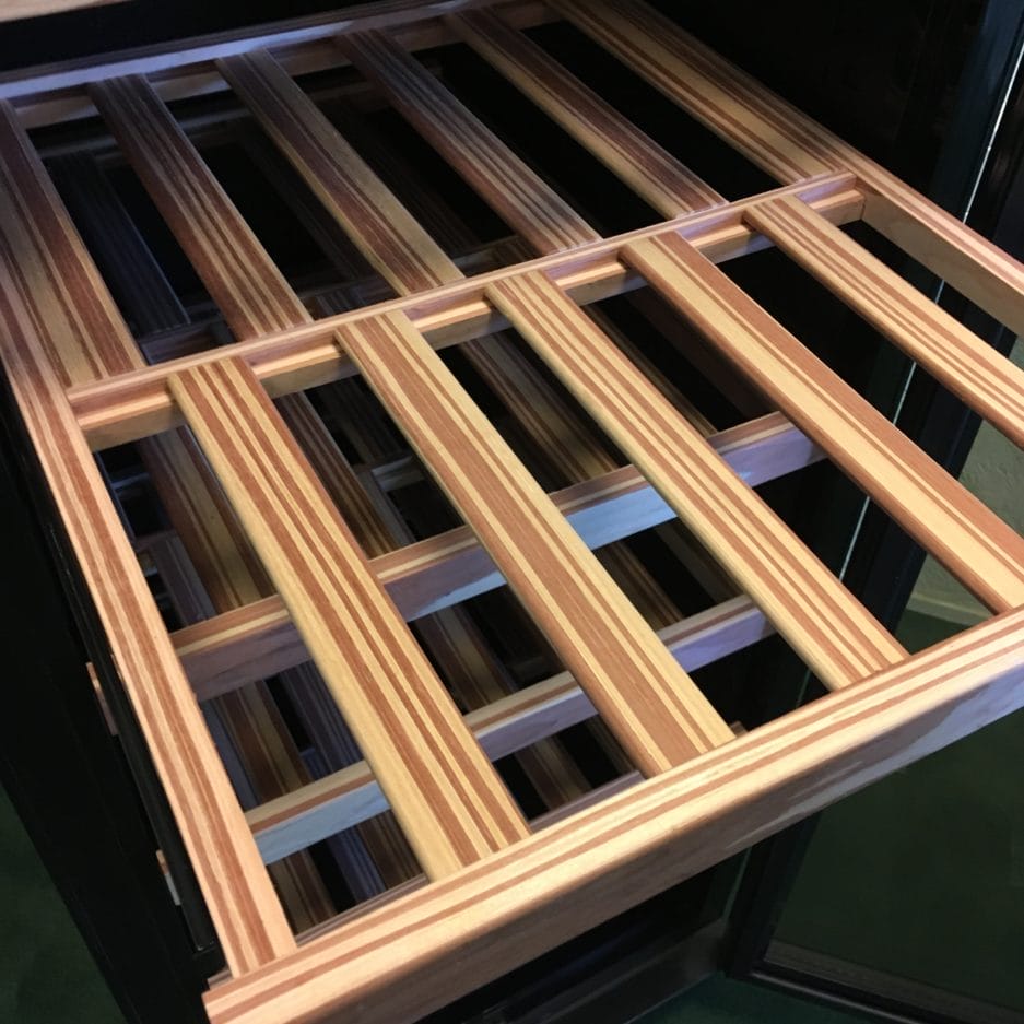 Top view of an empty wooden lattice framework on a black metal base, with a geometric pattern of parallel and perpendicular slats.