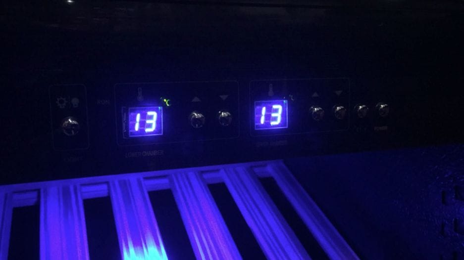 Digital display on laboratory equipment with temperature settings, backlit in blue, with visible controls and sample slots.