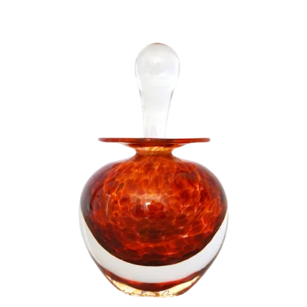 Een oranje, rond glazen parfumflesje met een transparante stop, geplaatst tegen een zwarte achtergrond.
